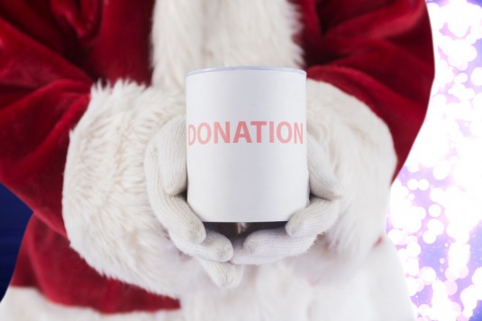 Composite image of santa holds a can for donations