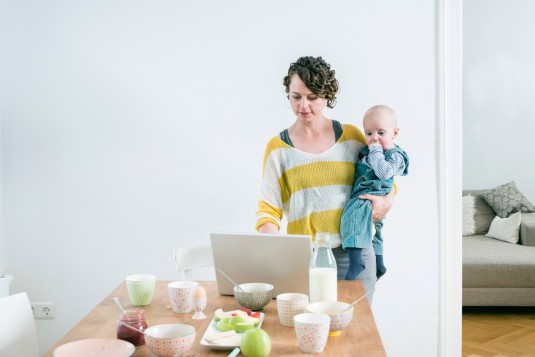 Mother with laptop and children in kitchen